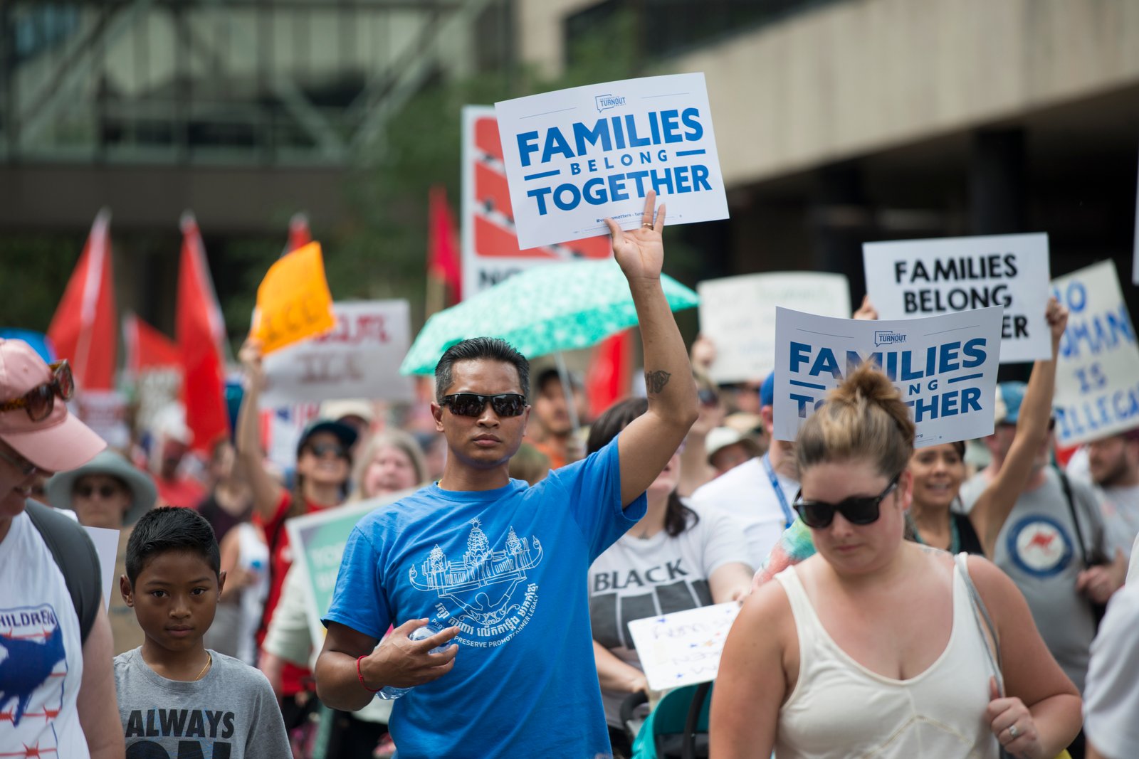 Families holding handmade signs at a Families Belong Together day of action